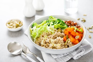 İnci arpalı, kırmızı fasulyeli, brokolili ve tereyağlı vejetaryen yemek kasesi.