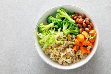 İnci arpalı, kırmızı fasulyeli, brokolili ve tereyağlı vejetaryen yemek kasesi.