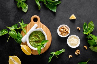 Mutfak masasında yemek pişirmek için malzemeli fesleğen ezmesi.