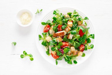 Izgara tavuk etli Sezar salatası, taze domates, kızarmış ekmek, kuzu salatası ve parmesan peyniri. Sağlıklı öğle yemeği. Üst görünüm