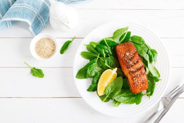 Somon balığı fileto ızgara ve öğle yemeği için taze ıspanak salatası. Üst görünüm