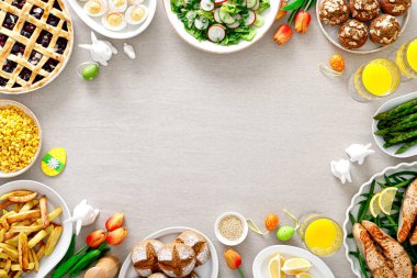 Somon, kuşkonmaz, salata, patates, kek ve böğürtlenli Paskalya bayramı masası.