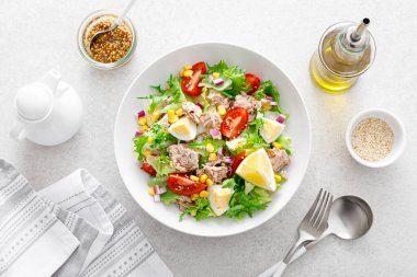 Haşlanmış yumurta, domates, marul, mısır ve kırmızı soğanlı ton balığı salatası. Sağlıklı ve detoks gıda konsepti. Ketogenik diyet. Beyaz arka planda taze sebze salatası kasesi. Üst görünüm