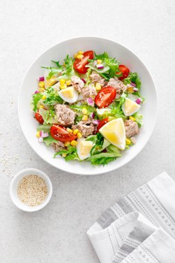 Haşlanmış yumurta, domates, marul, mısır ve kırmızı soğanlı ton balığı salatası. Sağlıklı ve detoks gıda konsepti. Ketogenik diyet. Beyaz arka planda taze sebze salatası kasesi. Üst görünüm