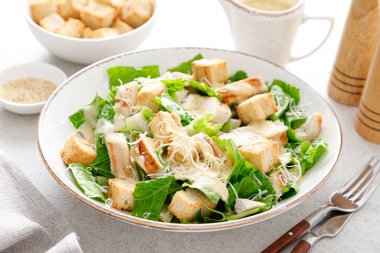 Parmesan peynirli Sezar salatası, kızarmış tavuk eti ve kızarmış ekmek.