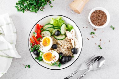 Sağlıklı kahvaltı için taze salatalık, dolma biber, zeytin, marul, feta peyniri, turp filizi ve rafadan yumurta ile Yunan esinlenmiş lezzetli yulaf ezmesi.