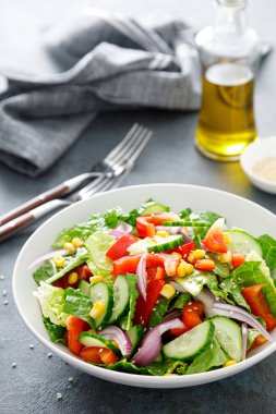 Vejetaryen taze sebze salatası, salatalık, kırmızı dolma biber, kırmızı soğan, mısır ve yeşil marul.