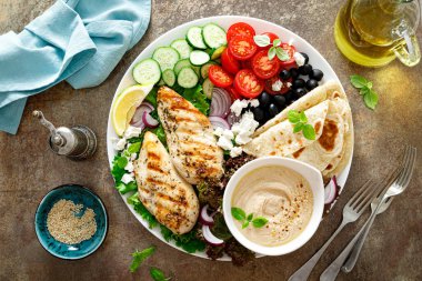 Taze sebzeli tavuk göğsü, zeytin, feta peyniri, yassı ekmek ve humus.