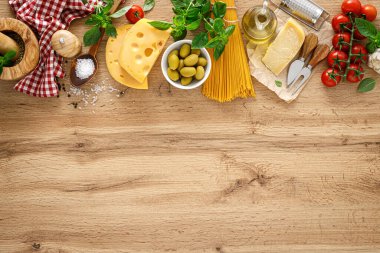 İtalyan yemeği. Mutfak konsepti arka planında ahşap mutfak kırsal masasında yemek pişirmek için malzemeler, fotokopi alanı olan üst manzara. Makarna pişirmek için gerekli malzemeler.