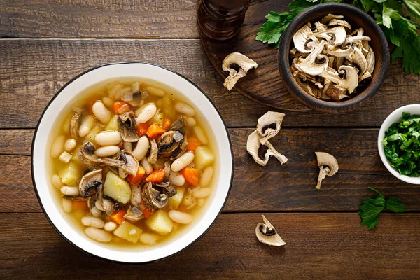 Mushroom soup with kidney bean, potato and carrot. Top view, copy space