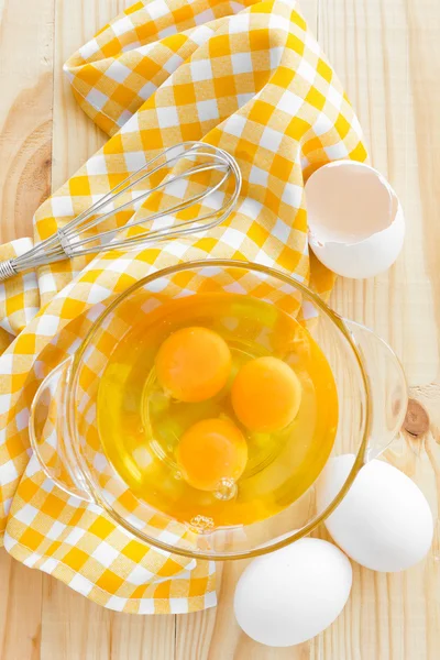 Raw eggs and whisk — Stock Photo, Image