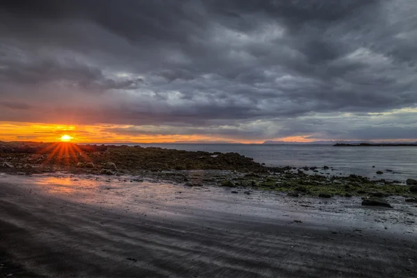 Sunset and rough rocky coast — Stock Photo, Image