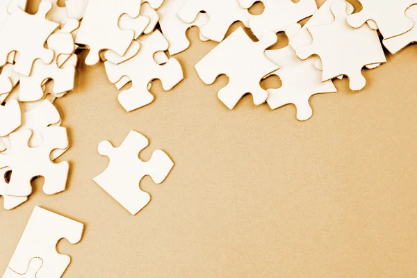 Puzzle pieces on brown — Stock Photo, Image