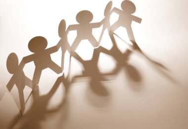 Kağıt zincire bağlı insanlar el ele tutuşuyorlar.