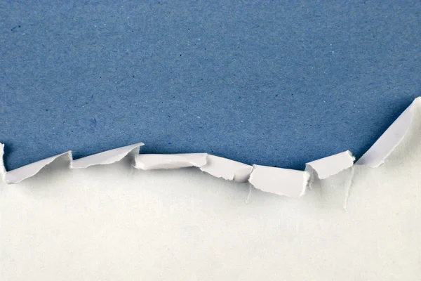 Ripped paper on blue — Stock Photo, Image