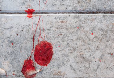 Beton bir duvarın yüzeyinde, üzerinde uzayın bir kopyası olan parlak kırmızı bir kan damlası. Suçun teması, tehlike.