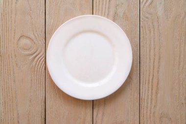 Boş beyaz bir tabak, tahtalar üzerinde, doğal ahşap, metin için boşluk, kopyalama alanı