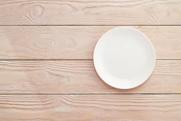 Boş beyaz bir tabak, tahtalar üzerinde, doğal ahşap, metin için boşluk, kopyalama alanı