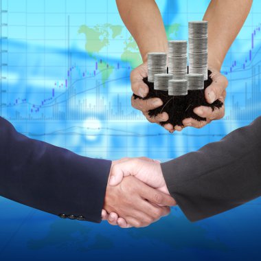 İki iş adamının eli, bulanık arka planda titriyor.