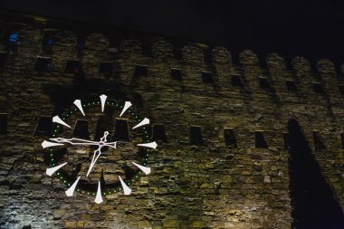 Azerbaycan Bakü 'deki eski kasaba duvarında büyük bir saat var.