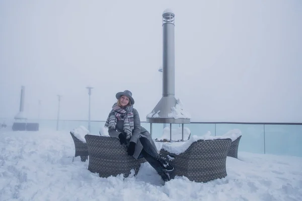 A young woman posing in a restaurant covered with snow at the cable car station, the mountain Tufandag, Gabala, Azerbaijan