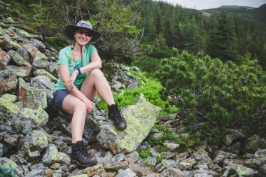 Genç bir kadın yürüyüşçü kayalık patika üzerinde Karpat Dağları 'nda seyahat ediyor. Gorgany aralığı