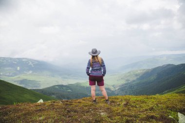 Rear view of a young woman hiker traveling in the Carpathian Mountains. Gorgany range