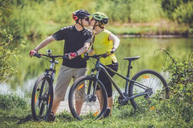 Happy young couple riding bicycles outdoors