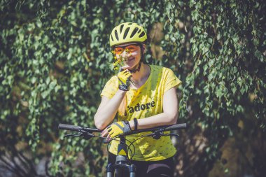 Woman cyclist riding country road in summer time