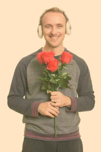 Boldog jóképű fehér férfi kezében vörös rózsa készen Valentin-napra — Stock Fotó