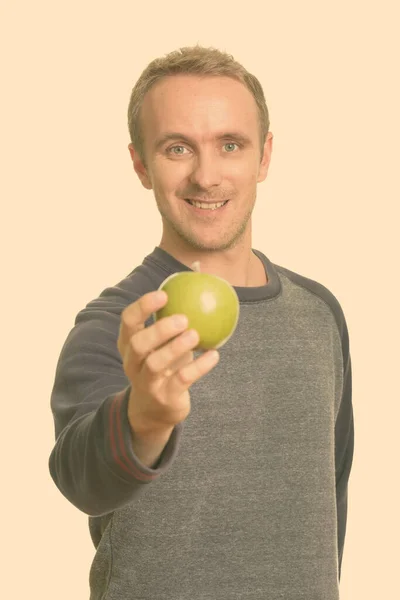 Boldog jóképű fehér férfi zöld almát ad — Stock Fotó