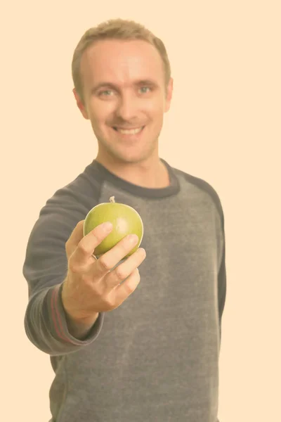 Mutlu yakışıklı beyaz adam yeşil elma veriyor — Stok fotoğraf