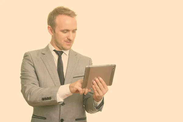 Retrato de hombre de negocios guapo en traje usando tableta digital — Foto de Stock