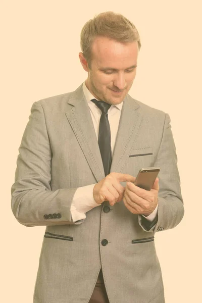 Feliz guapo hombre de negocios rubio en traje usando el teléfono — Foto de Stock