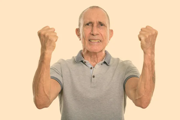 Studio shot of angry senior man with both arms raised — Stock Photo, Image