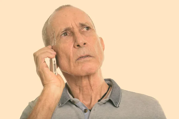 Close-up van senior man praten op mobiele telefoon tijdens het denken — Stockfoto