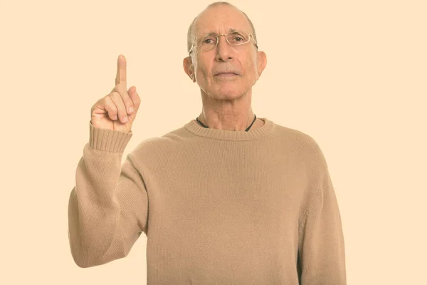 Studio colpo di uomo anziano che indossa occhiali mentre punta il dito verso l'alto — Foto Stock