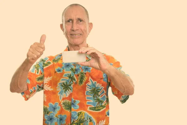 Feliz hombre mayor sonriendo mientras toma una foto con el teléfono móvil y dando pulgar hacia arriba —  Fotos de Stock