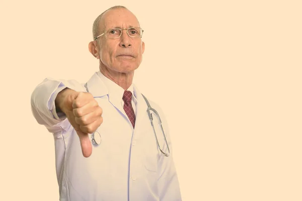 Studioshot av senior man läkare ger tummen ner — Stockfoto
