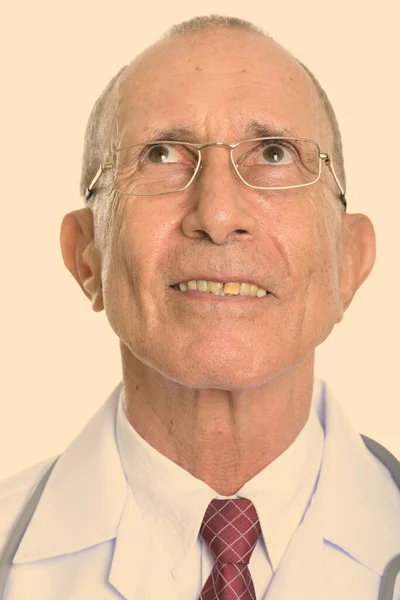 Volto di felice anziano uomo medico sorridente mentre pensa — Foto Stock