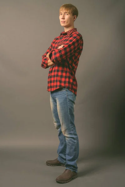 회색 배경에 금발 머리를 하고 있는 잘생긴 청년 — 스톡 사진