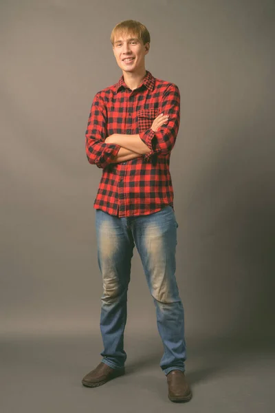 Joven hombre guapo con el pelo rubio sobre fondo gris — Foto de Stock