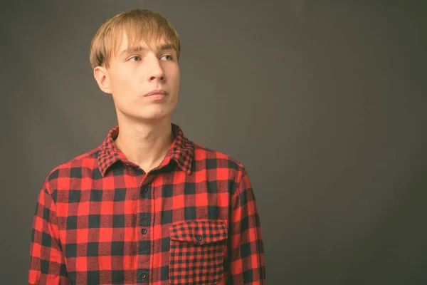 Ung stilig man med blont hår mot grå bakgrund — Stockfoto