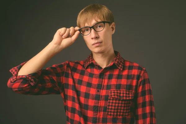 Ung stilig man med blont hår mot grå bakgrund — Stockfoto