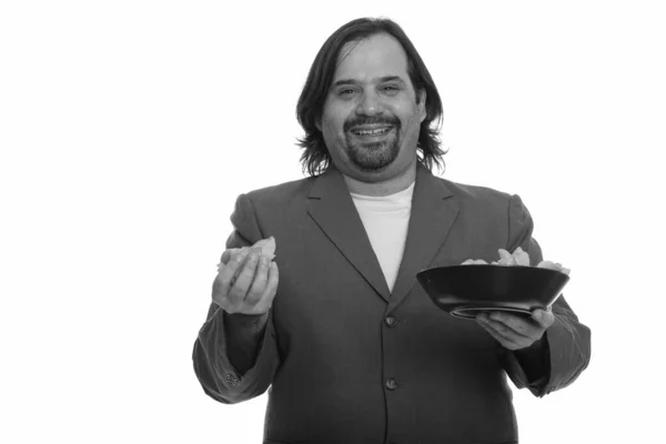 Glücklicher fetter kaukasischer Geschäftsmann lächelt und hält einen Schluck Chips in der Hand — Stockfoto