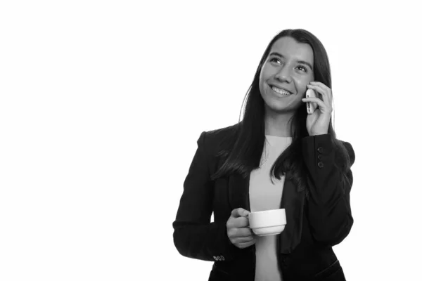 Nachdenklich glückliche kaukasische Geschäftsfrau lächelt und telefoniert, während sie eine Kaffeetasse in der Hand hält — Stockfoto