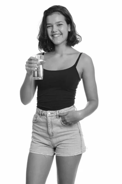 Jovem feliz adolescente caucasiana sorrindo e segurando vidro de água — Fotografia de Stock