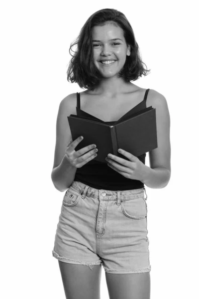 Joven feliz caucásico adolescente sonriendo mientras sostiene libro — Foto de Stock