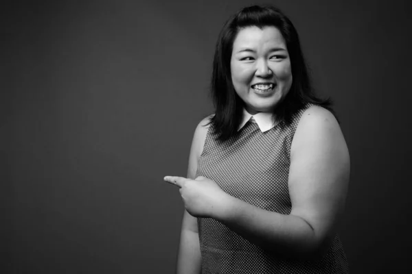 stock image Beautiful overweight Asian woman against gray background