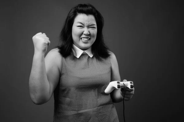 美しいです太りすぎアジアの女性に対する灰色の背景 — ストック写真